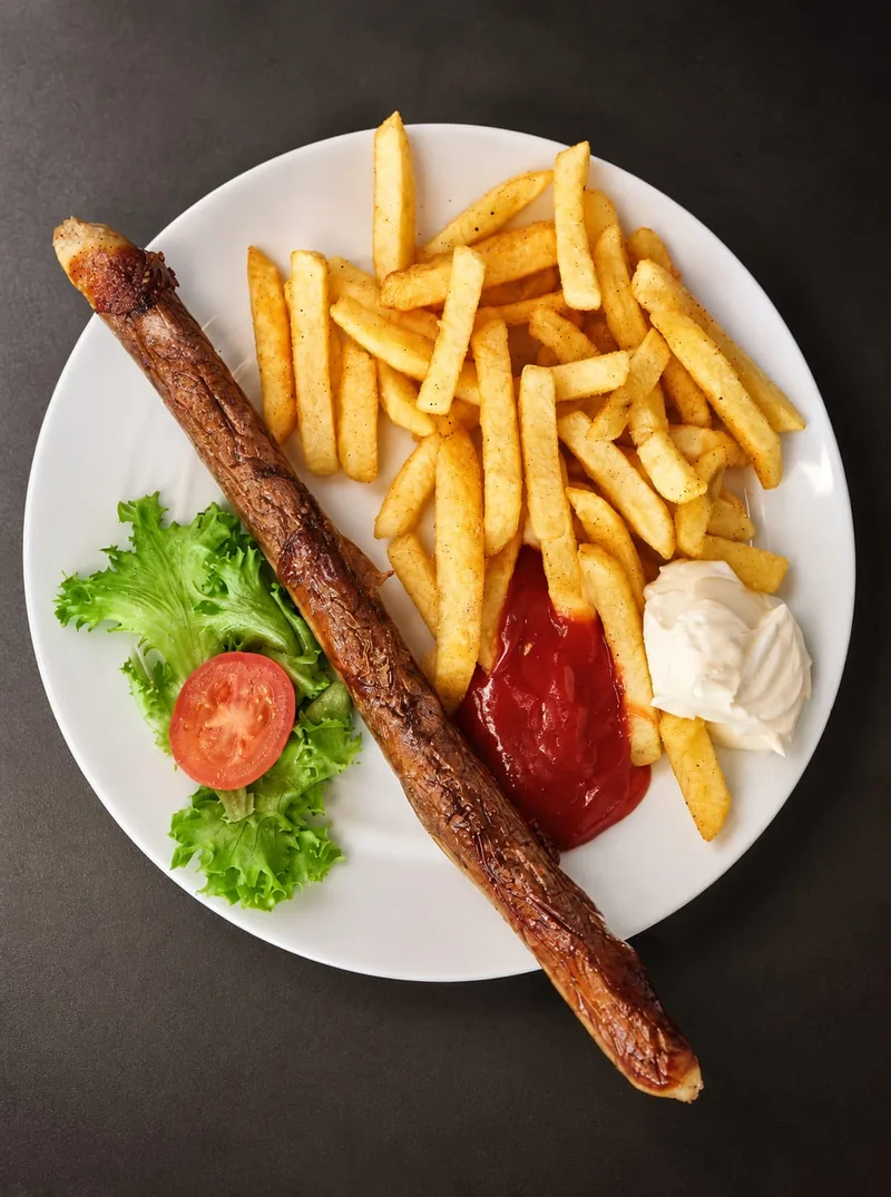 Paniertes Schnitzel mit Paprikasauce Balkan-Art und Bratkartoffeln